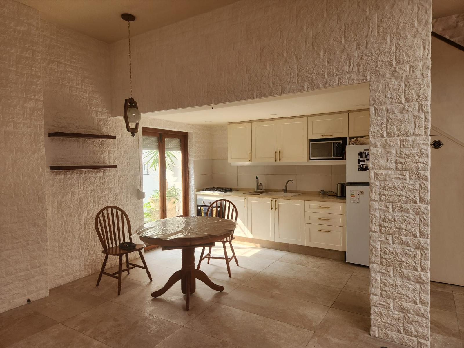 Cocina y comedor amplio con revestimiento